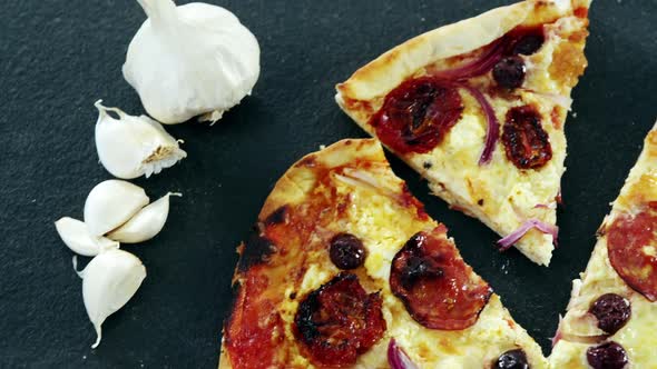 Italian pizza on wooden table with vegetables and spices