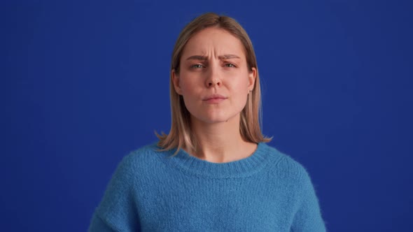 Displeased woman wearing blue sweater disagree with something