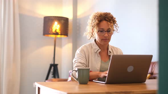 Head shot pleasant happy young woman freelancer working on computer at home - online smart working