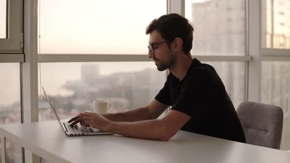 Joyful Man Using Laptop Computer at Remote Workplace in Slow Motion