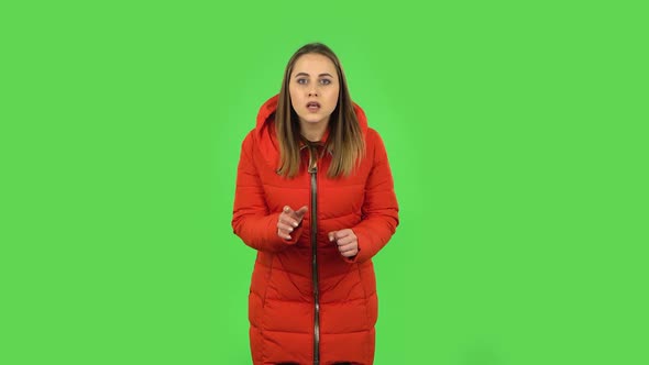 Lovely Girl in a Red Down Jacket Is Looking at Camera with Anticipation, Then Very Upset. Green