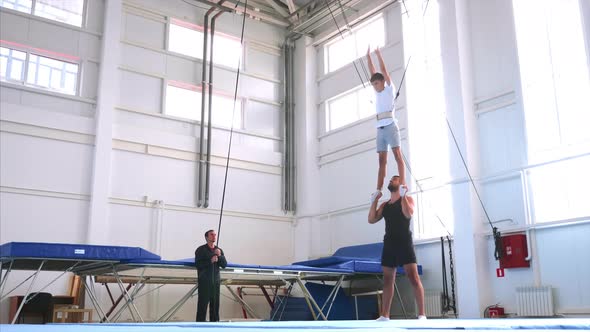 A Slow Motion of a Young Athlete Doing an Air Back Flip on Safety Slings