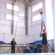 A Slow Motion of a Young Athlete Doing an Air Back Flip on Safety Slings - VideoHive Item for Sale