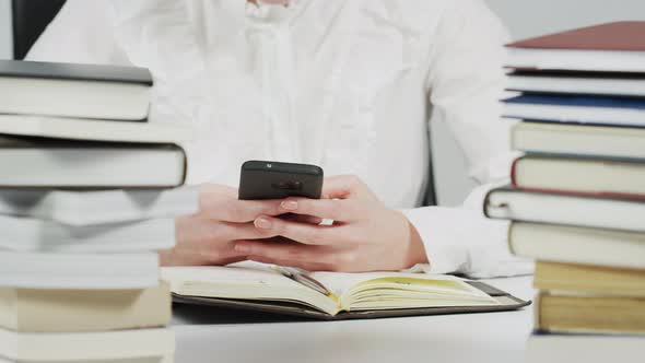 Librarian woman checking phone at the desk