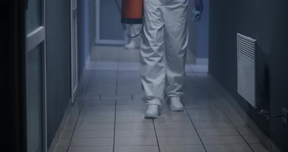 Men in Hazmat Suits Disinfecting Corridor