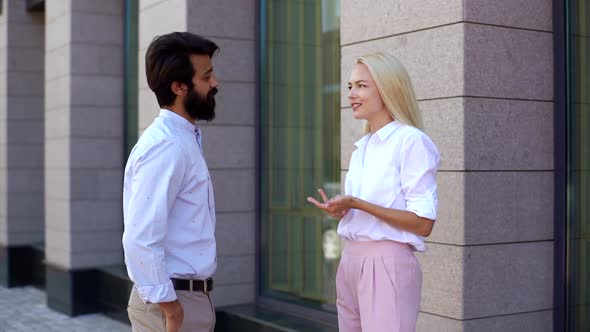 Medium Shot of Young Businesswoman Having Business Conversation with Caucasian Male Coworker