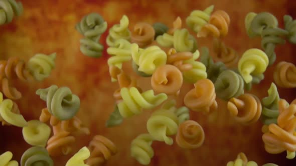 Dry Colored Pasta Conchiglie Rigate Flying Up on a Yellow Ochre Background