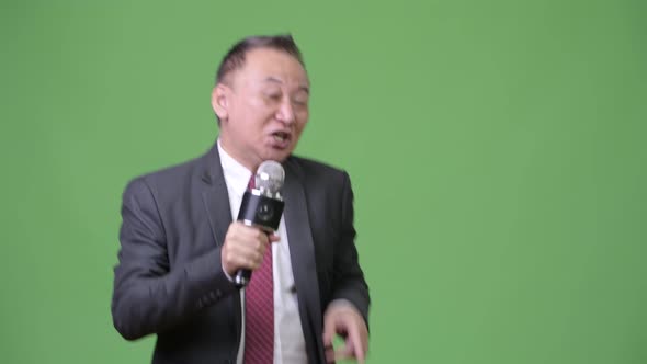 Mature Japanese Businessman Using Microphone