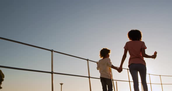 Mother and son walking at the sunset