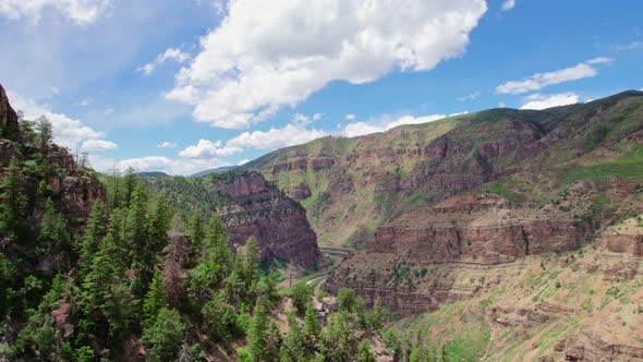 Aerial Shot Flying Backwards Over Alpine Forest Canyon Gorge Cliff Near Glenwood Canyon Colorado USA