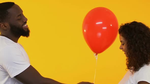 Afro-American Man Giving Balloon to Pretty Woman, Birthday Greeting, Affection