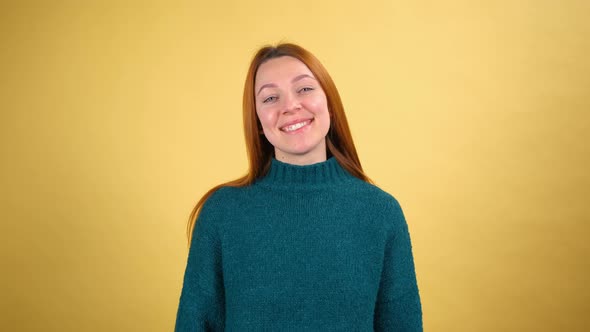 Young Red Hair Woman in Green Sweater Posing Isolated on Yellow Color Background Studio