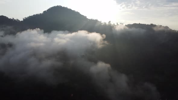 Aerial sliding view sun ray over the hill and morning low cloud