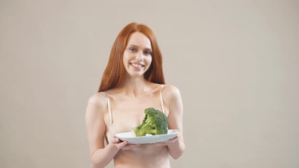 Joyful Skinny Girl Keeps Broccoli in a Plate, Afraid of Excess Weight, Anorexia