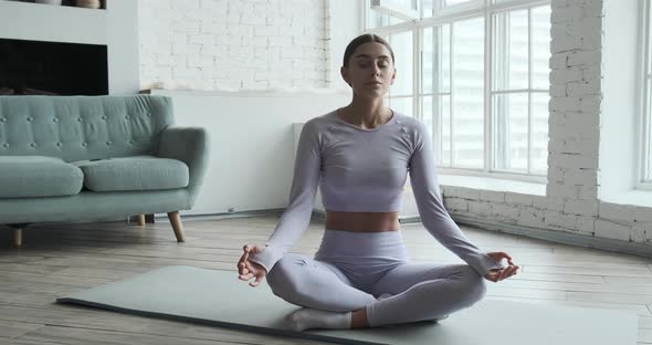 Young Happy Woman Practicing Yoga and Doing Breathing Exercises