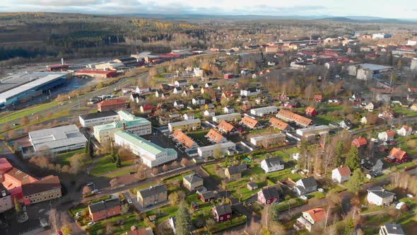 Drone footage panning over a residential area and a school in a small town with some industries in t