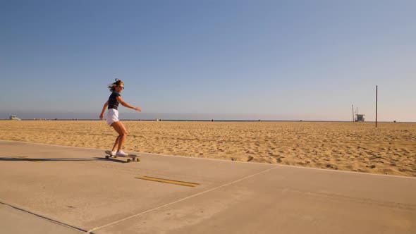 Female Skateboarder Dancing On A Rolling Skateboard At The Skatepark. wide, slow motion