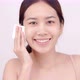 Happy Asian girl using cotton pad applying facial wipe on her face, removing makeup. - VideoHive Item for Sale