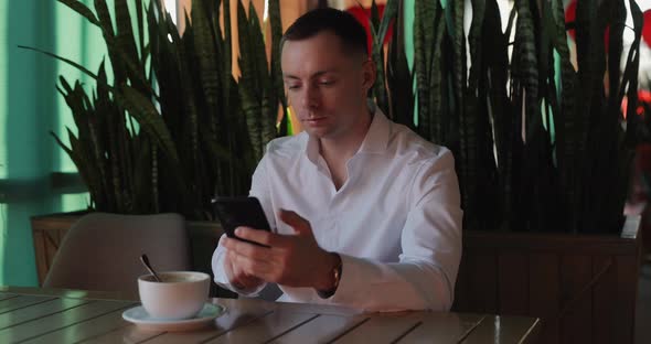 Man in Classical Suit Using Smartphone