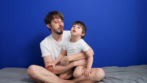 Restless Child 3 Years Old Fooling Around Jumping on His Father Sitting