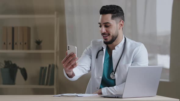 Male Doctor General Physician Hispanic Man Consulting Clients Online Using Via Mobile Telemedicine