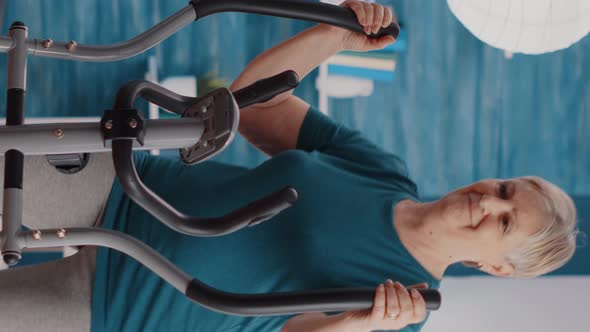 Vertical Video Retired Woman Training with Stationary Bicycle at Home