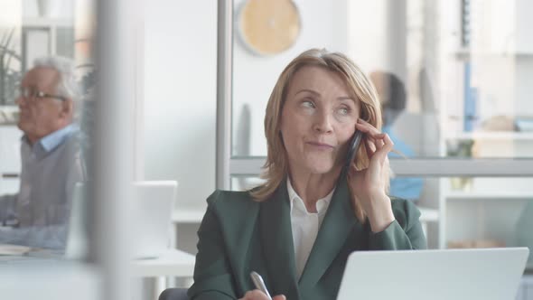 Middle-Aged Businesswoman Negotiating with Client on Phone then Smiling