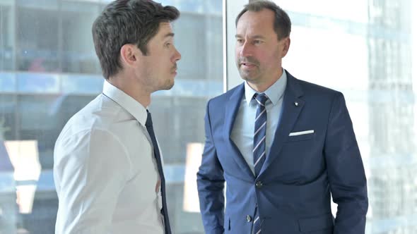 Cheerful Businessmen Shaking Hands and Having Conversation