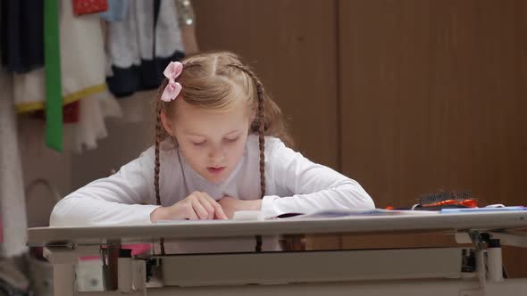 Schoolgirl Reading At The Desk