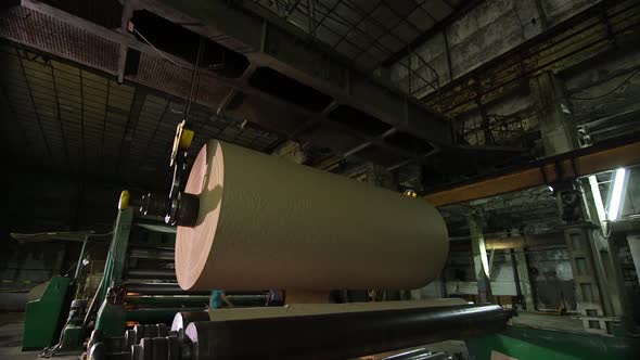 A Production Crane Lifts a Large Roll of Manufactured Paper