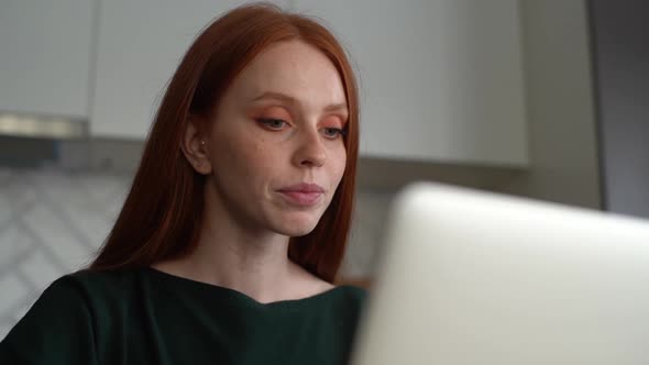 Closeup Lowangle View of Attractive Smiling Young Woman Using Typing on Laptop Computer Sitting at