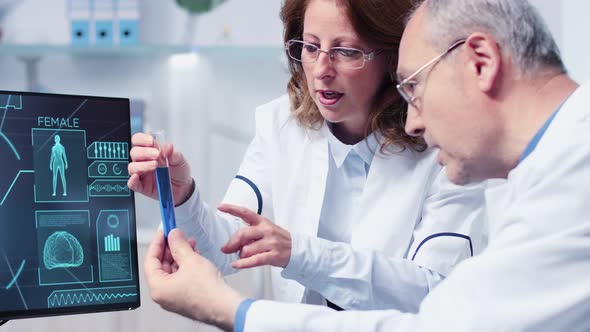 Female and Male Doctor Are Debating Over a Sample