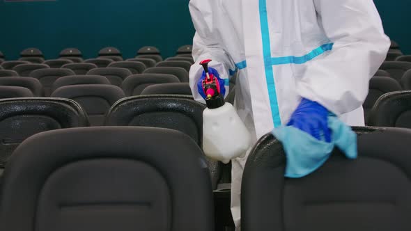 Close Up of Man Using Disinfectant for Cleaning Cinema