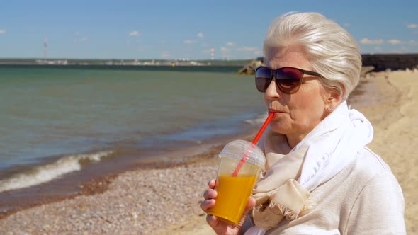 Senior Woman Drinking Shake on Summer Beach