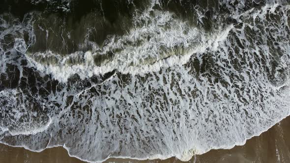 Aerial Drone View Flight Over Sea Waves That Roll Onto Sandy Shore