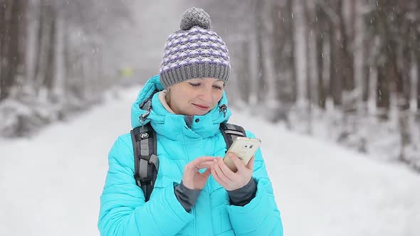 Beautiful Girl Taking Photos in the Winter Garden Snow Day