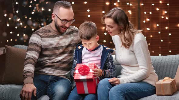 Astonished Boy Opening Christmas Gift Box with Shining Surprise