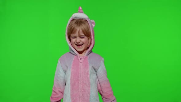 Little Blonde Child in Unicorn Costume Crying Wiping Tears with Her Hands on Chroma Key Background