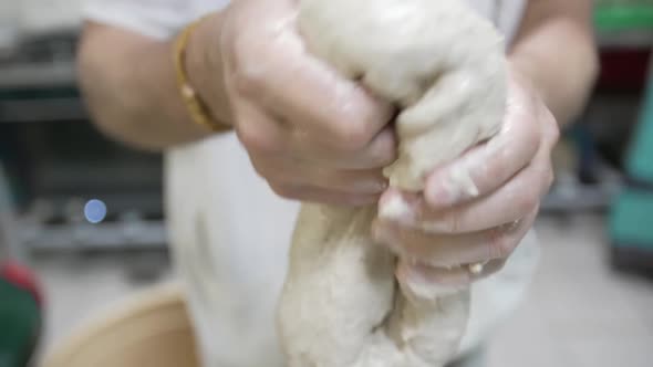 The Cook Kneads the Dough with His Hands