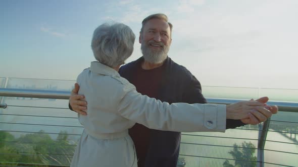 Happy Senior Couple Dancing Around and Enjoying Beautiful Cityscape