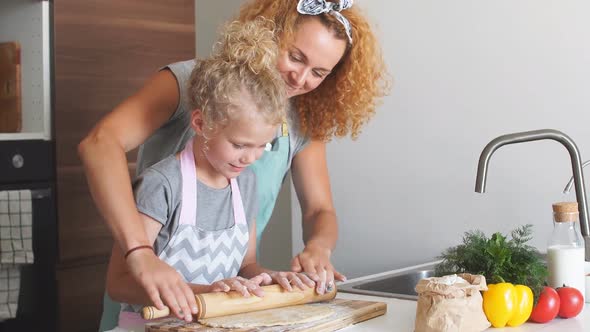 Young Little Girl Helping Her Mother Prepare Bread for the Holiday