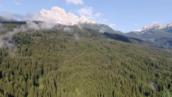 Drone flying over a forest in the Dolomites mountains, Italy