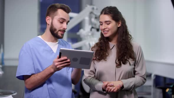 Dentist with Tablet Talking to Patient