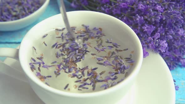 Tea from fresh lavender flowers on a vintage wooden background. 