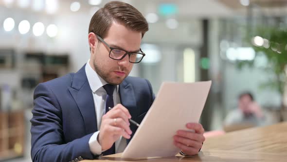 Professional Businessman Reading Documents at Work 