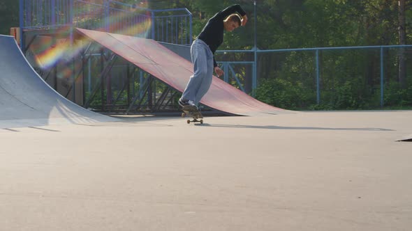 Young Man Skating on Two Wheels in Skatepark