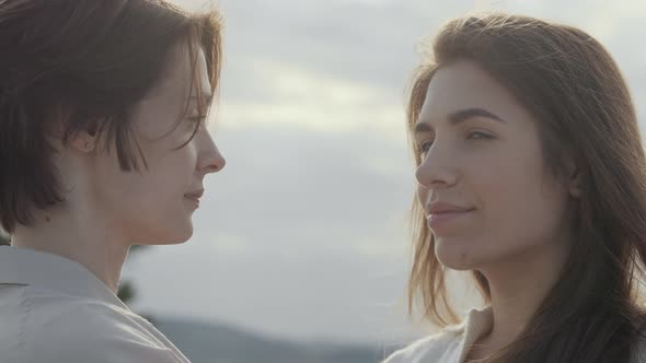 Women in Relations Standing Outdoors and Looking at Camera