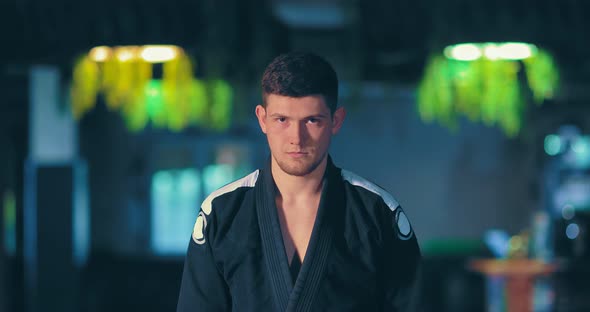 Male Athlete in a Black Kimono Looks at the Opponent a Serious Look