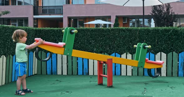 Kid Boy Having Fun to Play on Children Playground alt