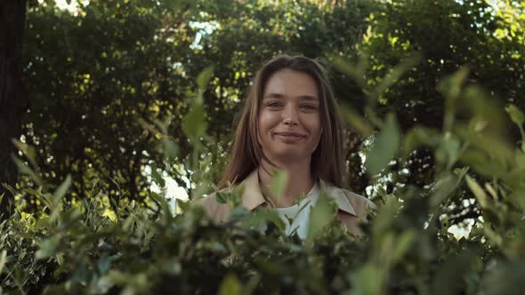 Woman Jumping out from Behind Bush